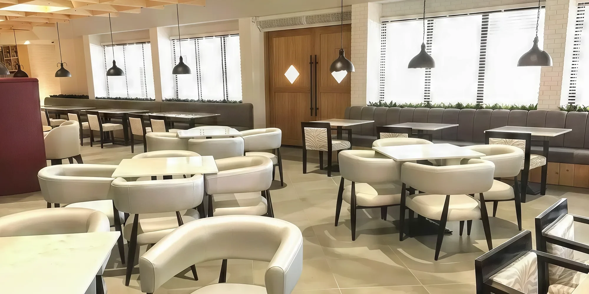 The Hide Restaurant, Abu Dhabi. Consisting of off white upholstered dining chairs and square dining table.